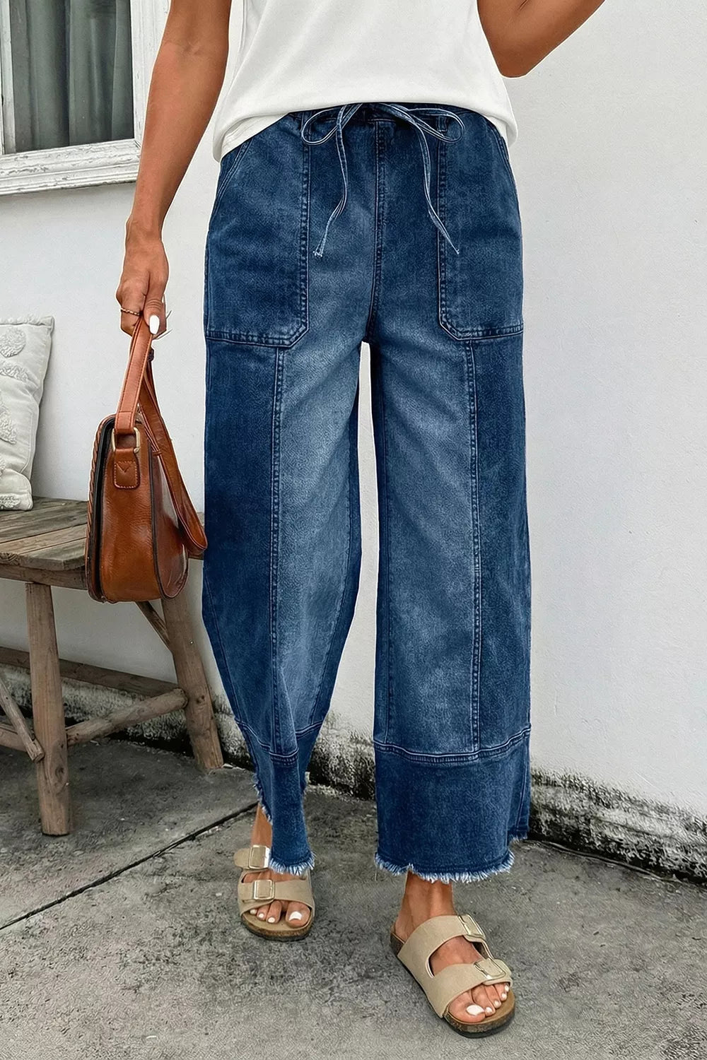 Wide leg jeans for women with drawstring seam and raw hem, styled with a casual outfit.