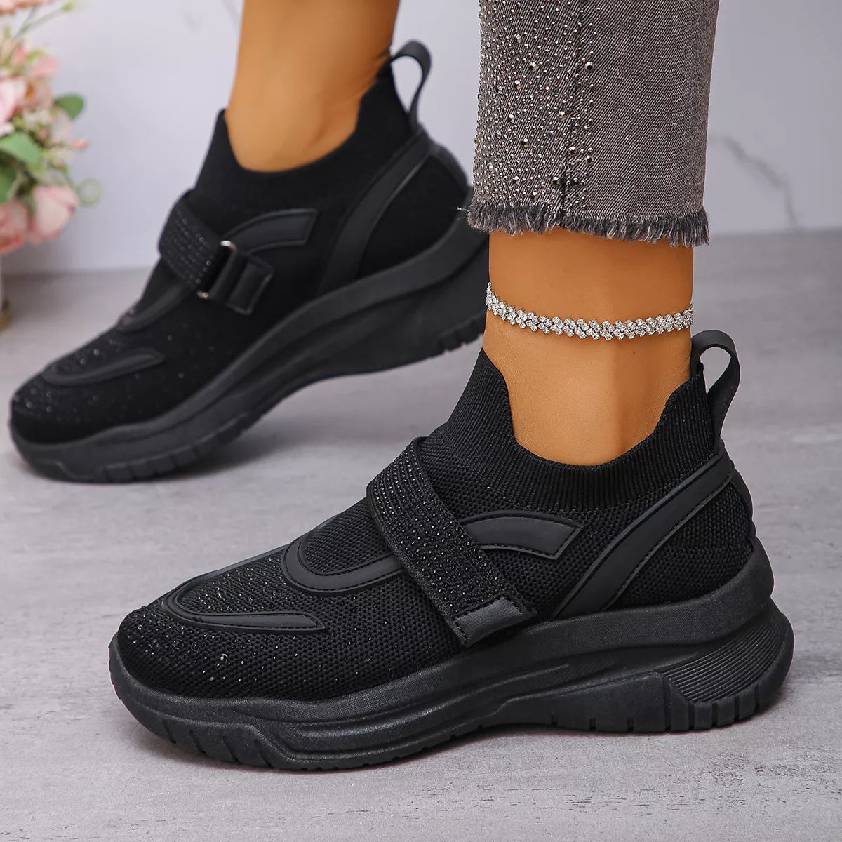 Black mesh sneakers with round toe design, featuring a stylish strap and breathable upper for comfort.