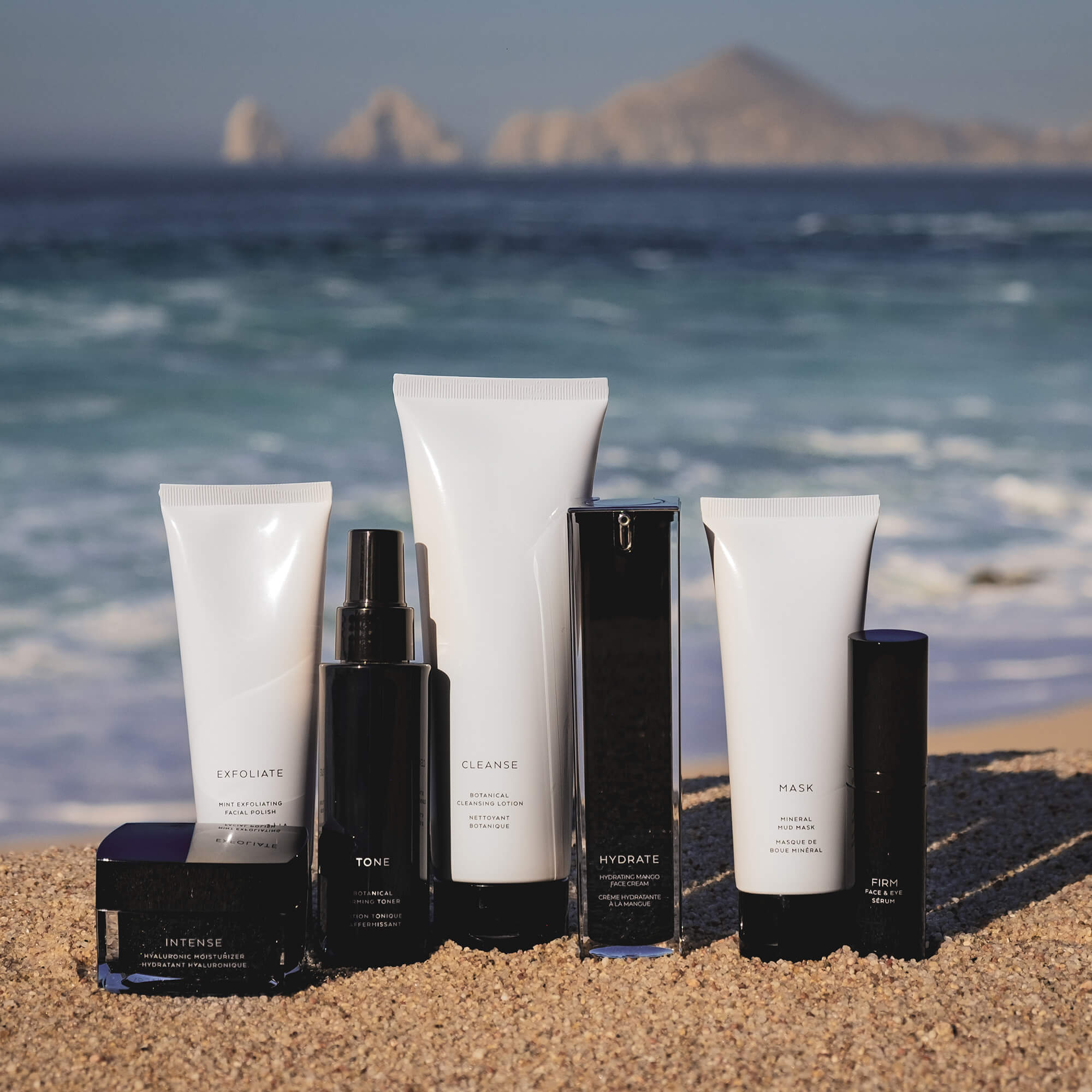 Hyaluronic moisturizer for dry skin among skincare products on a beach setting with ocean in the background.