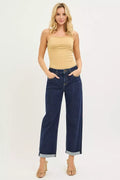 Model wearing slouchy cropped boyfriend jeans with cuffed hem and a nude tank top, exuding casual style.