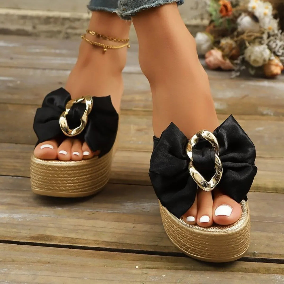 Wedge sandals with bow featuring gold chain detail and platform sole, perfect for summer outfits.
