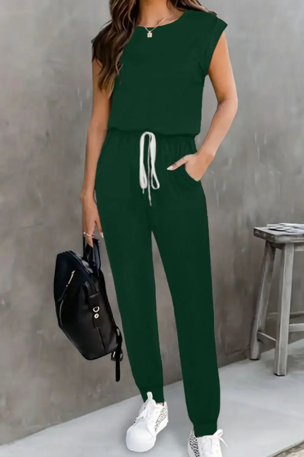 EmpowerEase Sleeveless Drawstring Jumpsuit in green, featuring adjustable drawstring waist and sleeveless silhouette.
