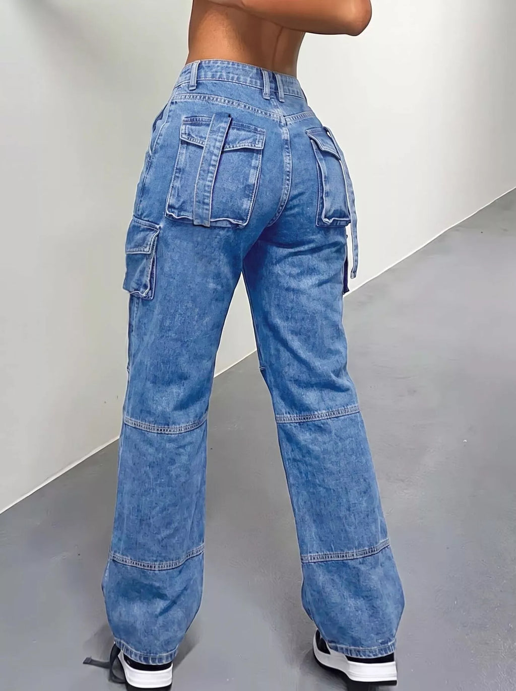 Trendy cargo jeans featuring a distressed high-waisted design, showcasing pockets and a relaxed fit from the back.