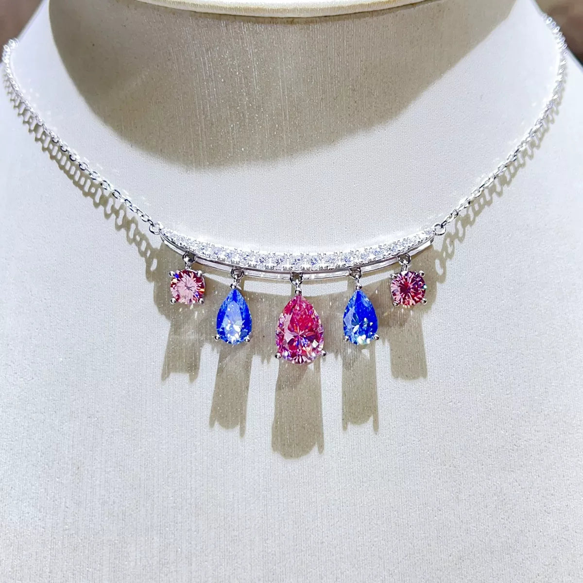 Teardrop Silver Necklace featuring colorful gemstones in pink and blue on a delicate silver chain.
