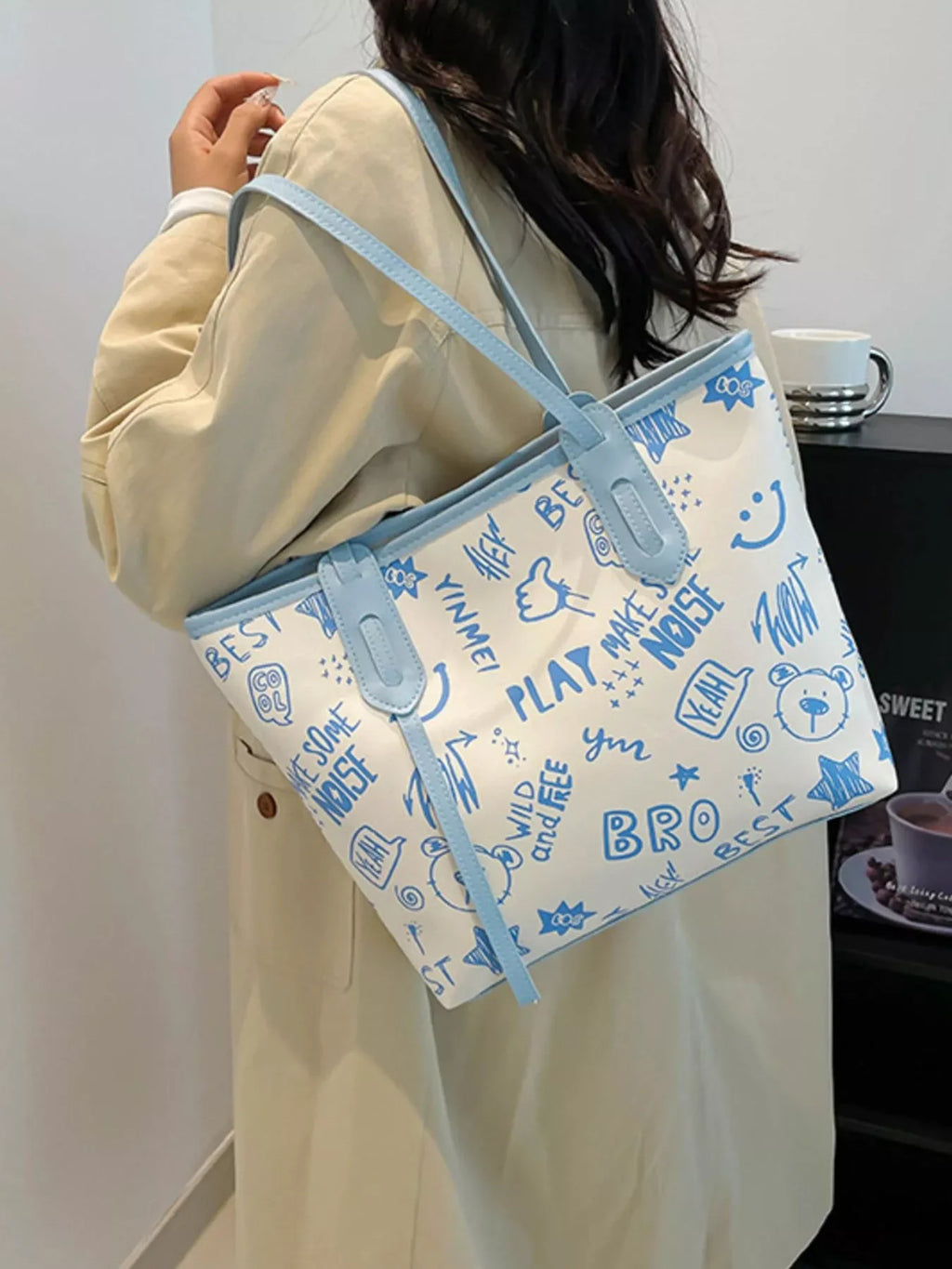 Graffiti Print Tote Bag – Large Canvas Shoulder Bag for Women showcased in street style with playful blue graphics.