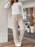 Woman wearing a two-piece wide-leg pants set featuring a long-sleeve top and beige pants.
