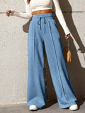 Wide Leg Drawstring Waist Pants in blue worn by a woman with a cropped top, showcasing a relaxed and stylish fit.