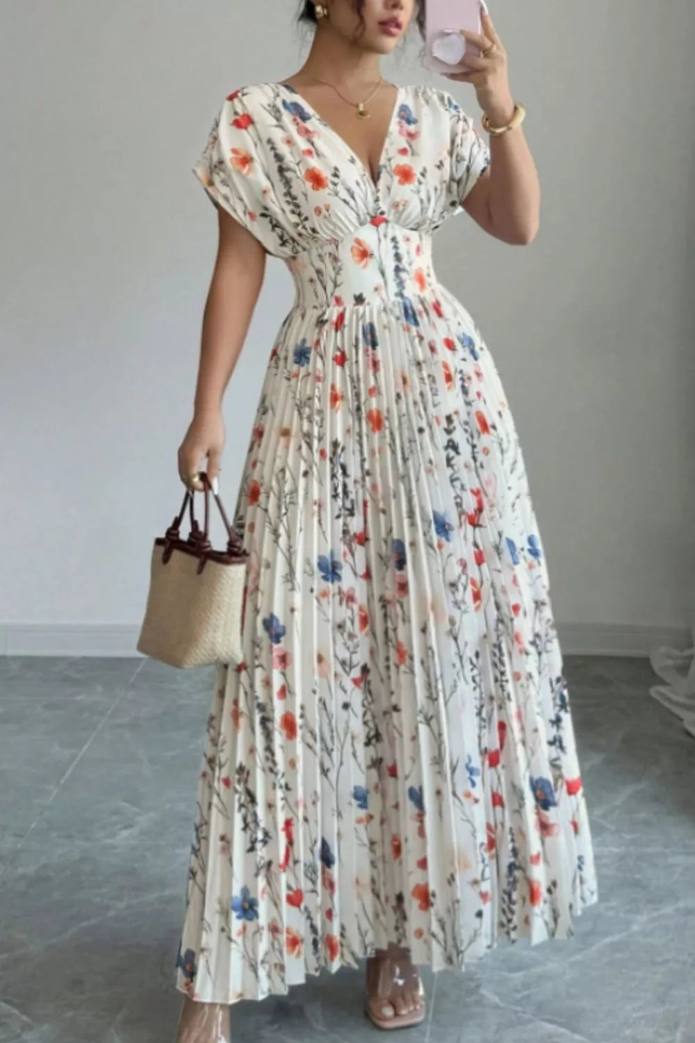 Woman wearing a floral dress for women, pleated maxi dress, showcasing its elegant design and colorful floral patterns.