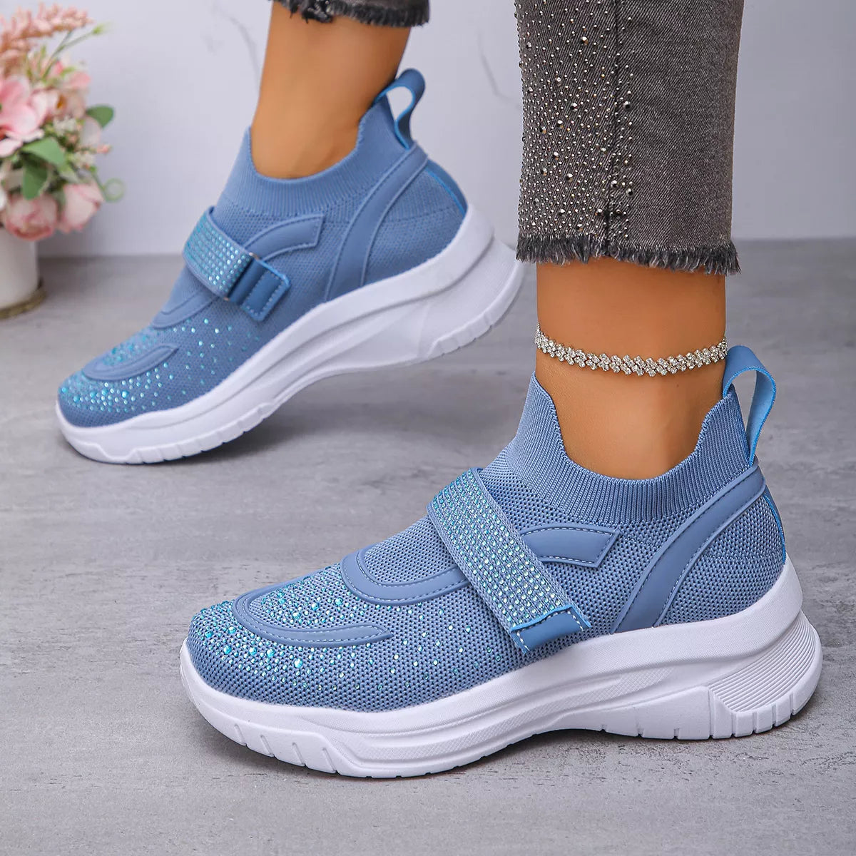 Light blue mesh sneakers with round toe design and strap, perfect for everyday comfortable footwear.