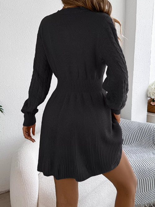 Back view of a woman wearing a Cable Knit Long Sleeve Sweater Dress in dark gray, showcasing its cozy design.