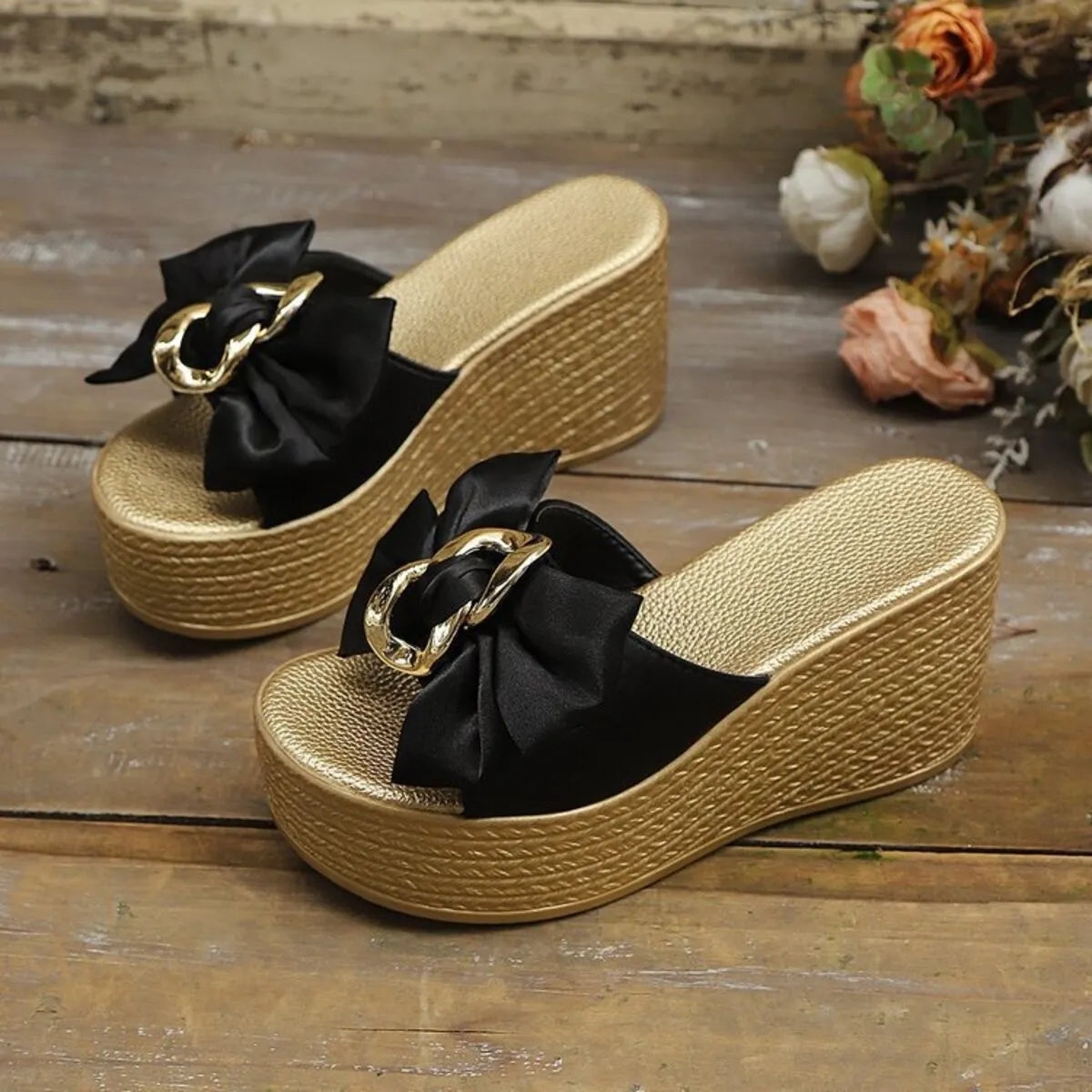 Wedge sandals with bow featuring a black fabric bow and gold accents, ideal for stylish summer outfits.