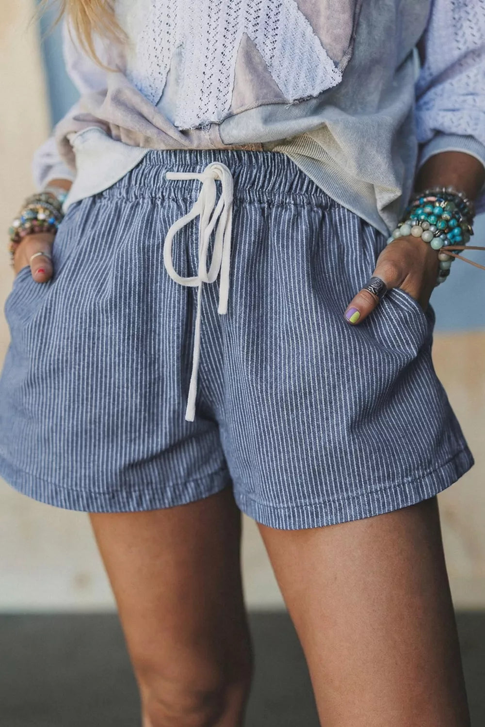 Drawstring denim shorts striped with pockets, featuring a comfortable fit and trendy design for casual outings.