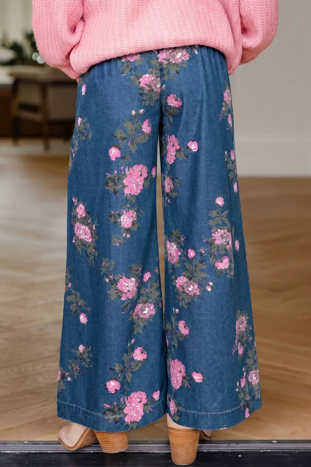 Casual view of floral wide leg jeans featuring a beautiful floral print in shades of pink and green.