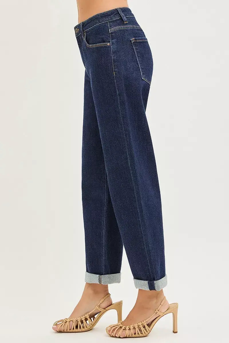 Slouchy cropped boyfriend jeans in dark denim with cuffed hem, styled with high-heeled sandals.