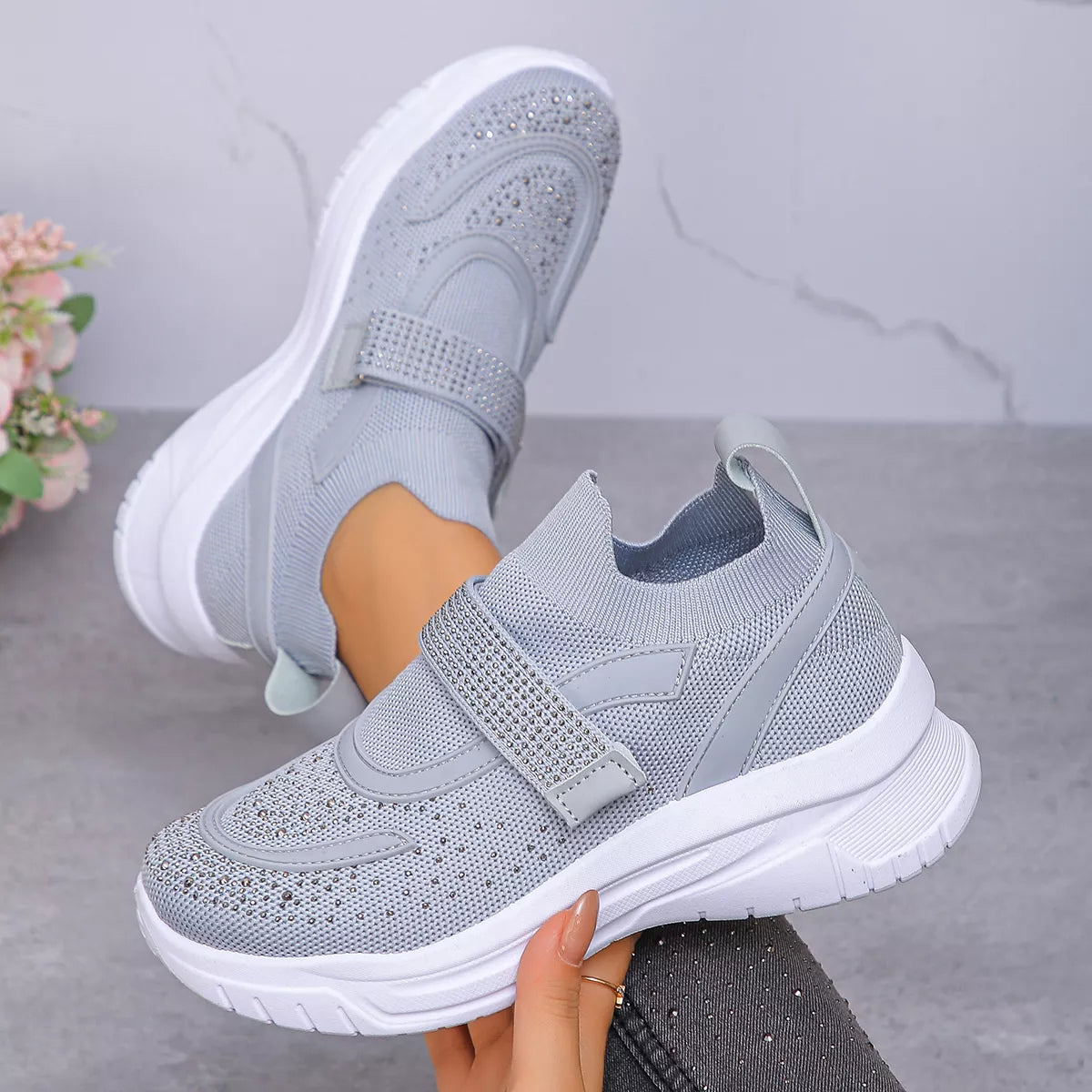 Light grey mesh sneakers with round toe and adjustable strap for a stylish and comfortable fit.