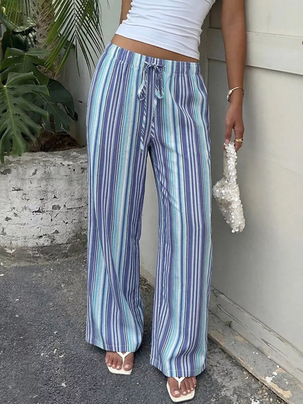 Model wearing Striped Wide-Leg Pants (Midnight Blue) with vibrant stripes and a relaxed fit.