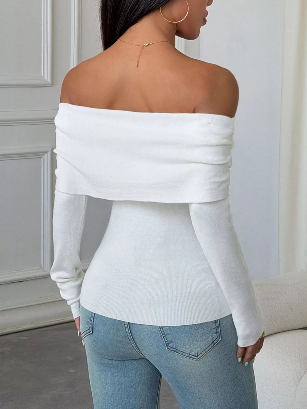 Elegant off-shoulder ribbed knit top in white with a slim-fit silhouette and ribbed texture, showcasing a stylish back view.
