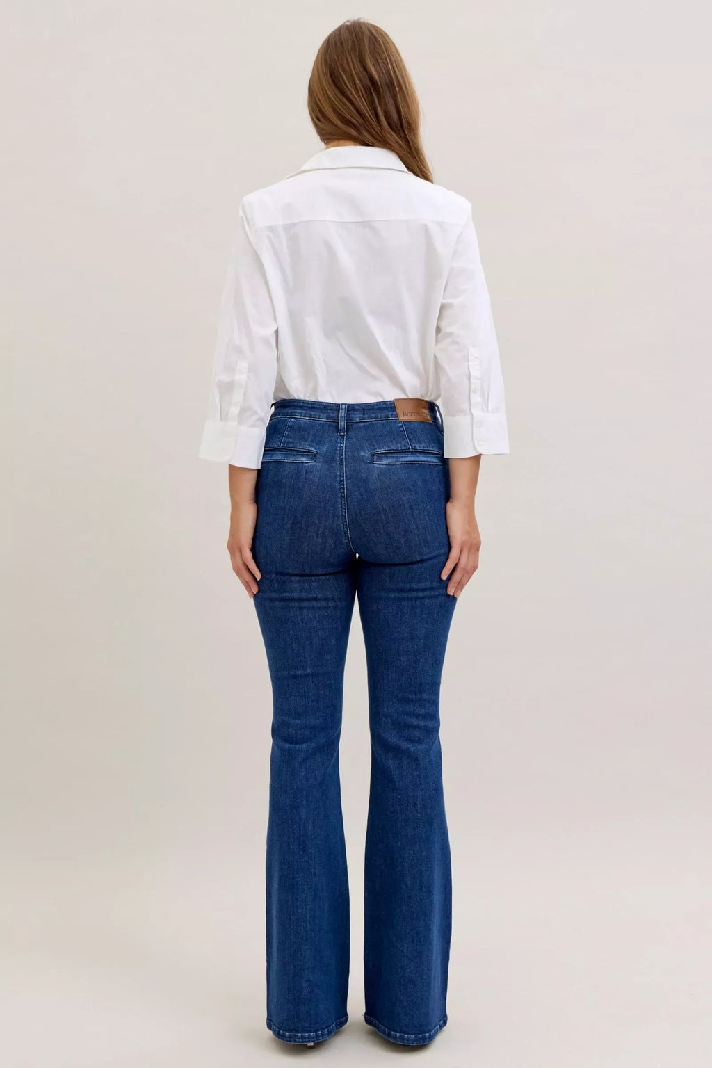 Dark High Waist Flare Jeans with Front Patch Pockets – Trendy Women’s Retro Denim worn with a white shirt from the back.