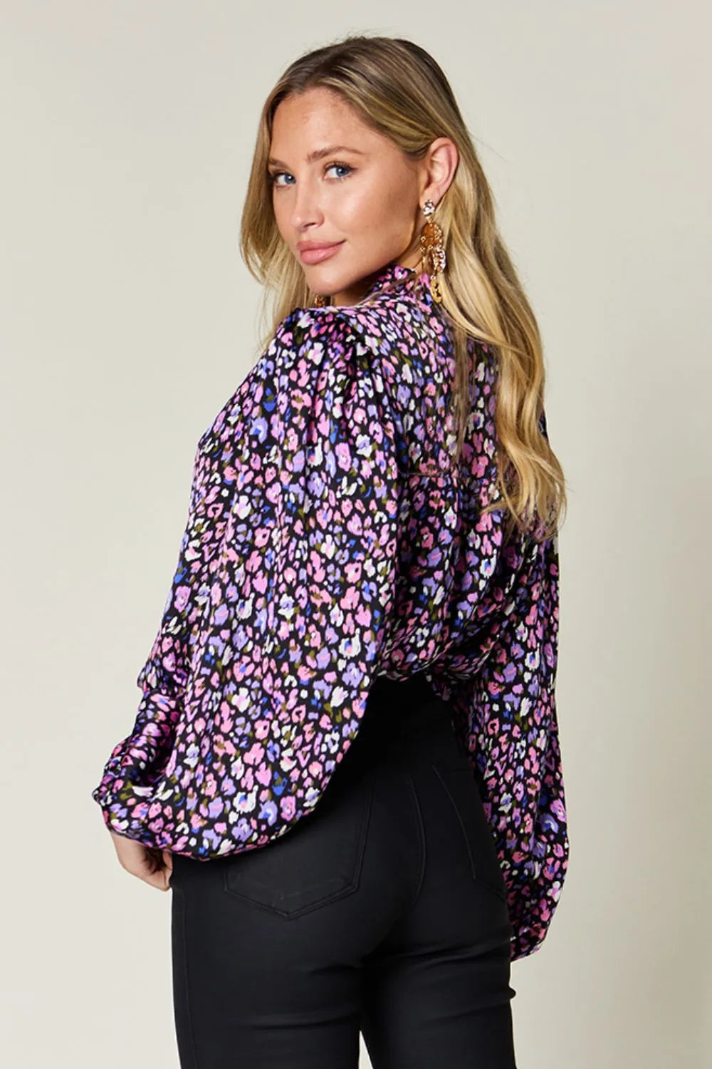 Model showcasing a stylish metallic purple balloon sleeve shirt with a vibrant floral pattern.