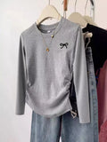 Cute Grey Bow Long Sleeve T-Shirt – Adorable Women’s Casual Top on a hanger with jeans and accessories.