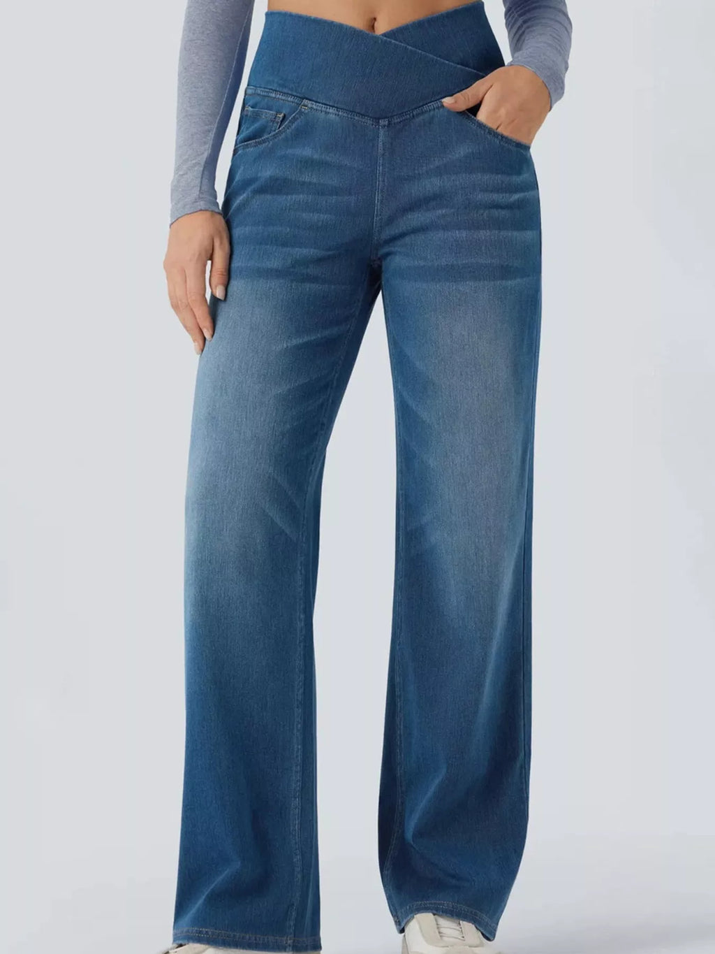 High-waisted crossover jeans featuring a crisscross design and a chic washed finish for comfortable all-day wear.