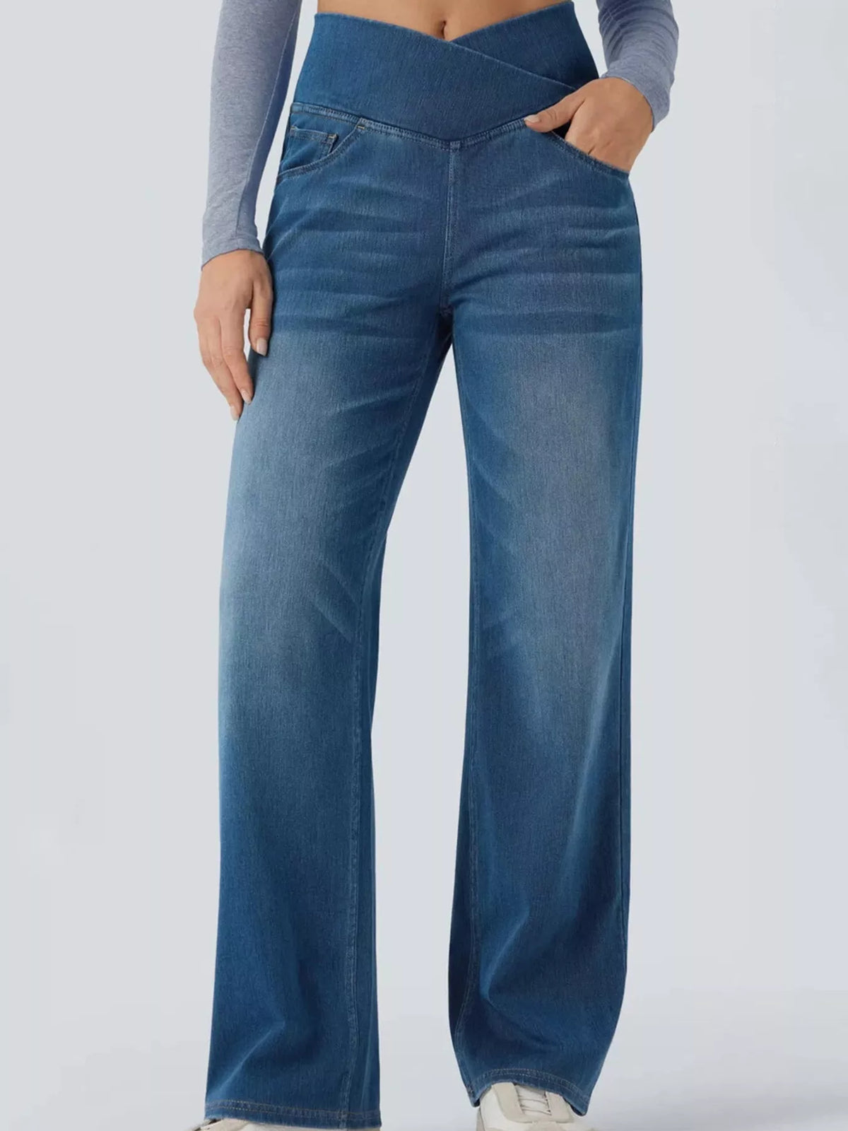 High-waisted crossover jeans featuring a crisscross design and a chic washed finish for comfortable all-day wear.