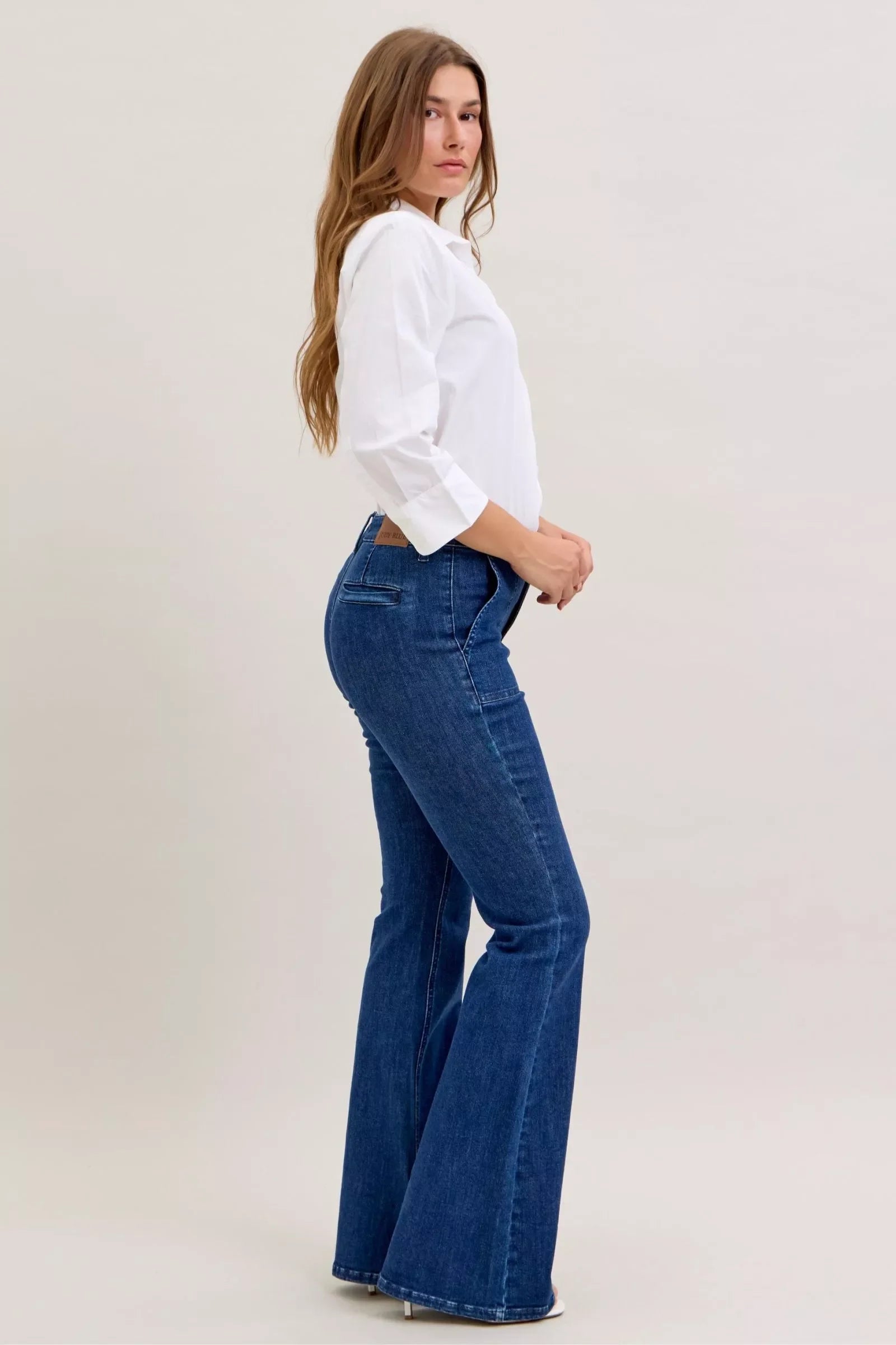 Dark High Waist Flare Jeans with Front Patch Pockets – Trendy Women’s Retro Denim worn by model with white shirt.